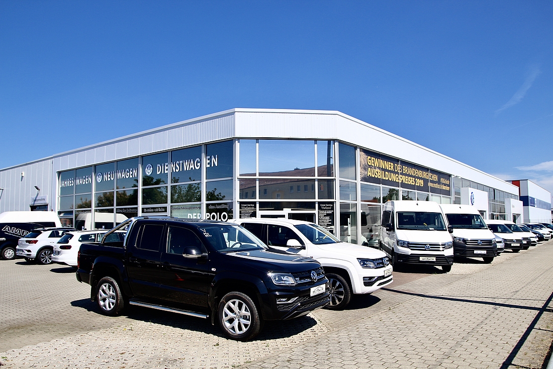 Außenansicht VW Autohaus Mothor in Brandenburg an der Havel mit großem Parkplatz und sehr großem Verkaufsraum sowie Werkstatt.